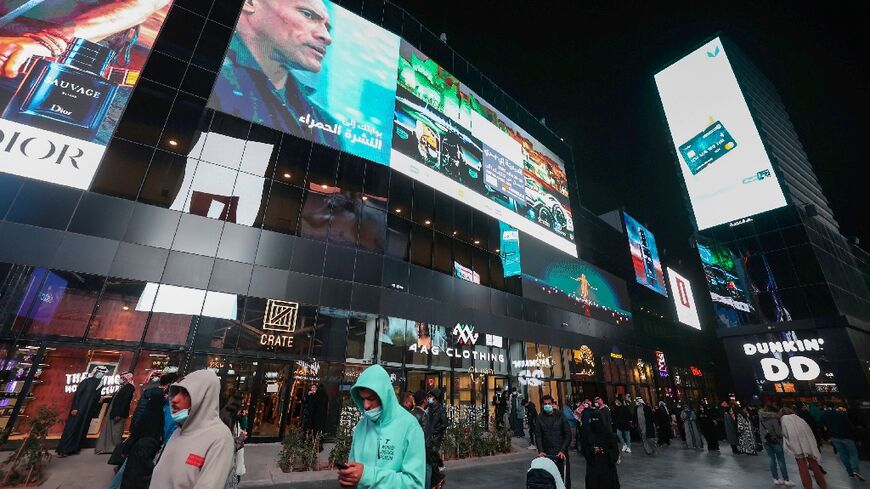 People walk beneath advertising billboards at Boulevard entertainment city in the Saudi capital Riyadh -- several analysts said the kingdom's youth are more open to ties with Israel