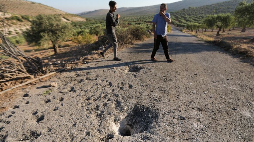 People inspect the site where a US drone targeted killed Maher al-Agal, a leader in the Islamic State militant group near Jindires in northern Syria.