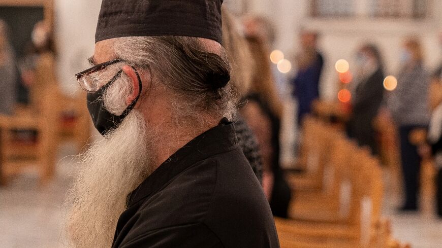 Mask-clad Greek Orthodox Cypriot priest attends mass at a church in the capital Nicosia