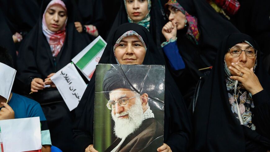 An Iranian woman holds a poster of Supreme Leader Ayatollah Ali Khamenei during a rally in support of wearing headscarves.