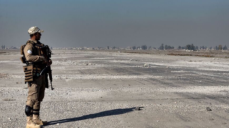 A member of Iraq's Hashid Shaabi paramilitary force looks on while standing along a runway at the heavily damaged airport of the northern city of Mosul.