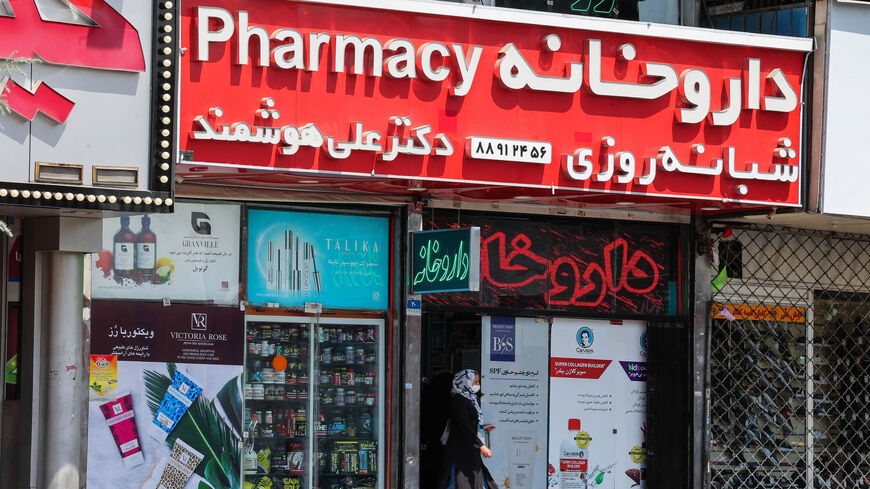 An Iranian woman leaves a pharmacy next to shuttered shops at Valiasr Square, Tehran, Iran, Aug. 16, 2021.