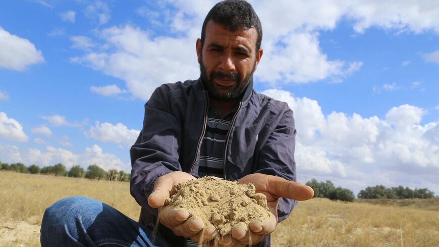 A farmer holds a handful of soil parched because of drought in Tunisia's east-central area of Kairouan.