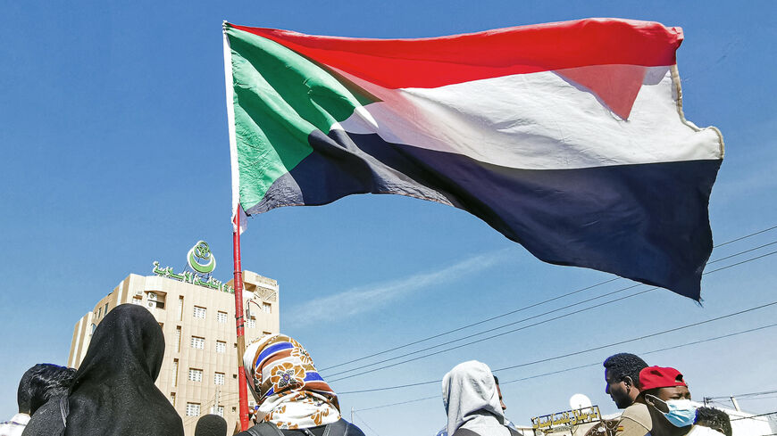 A demonstrator holds up a Sudanese flag during a protest demanding civilian rule in the "Street 40" of the Sudanese capital's twin city of Omdurman on Jan. 4, 2022.