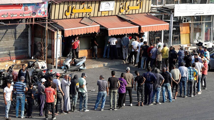 People line up in front of a bakery to buy bread in Lebanon's southern city of Sidon on June 22, 2022.