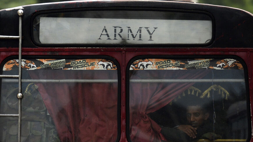 An army cadet looks through the window of a bus parked outside Sri Lanka's presidential palace in Colombo.