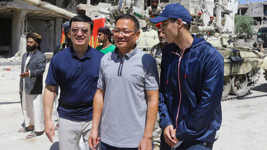 Chinese Ambassador to Syria Feng Biao (C) poses for a picture with crew members in Hajar al-Aswad neighborhood during the filming of "Home Operation," Damascus, Syria, July 14, 2022.