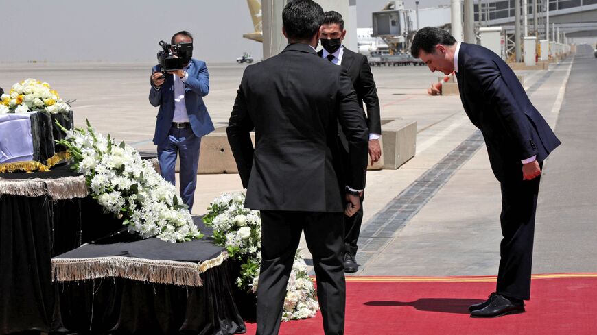 President of the Kurdistan Region in Iraq Nechirvan Barzani (R) pays tribute in front of a casket.