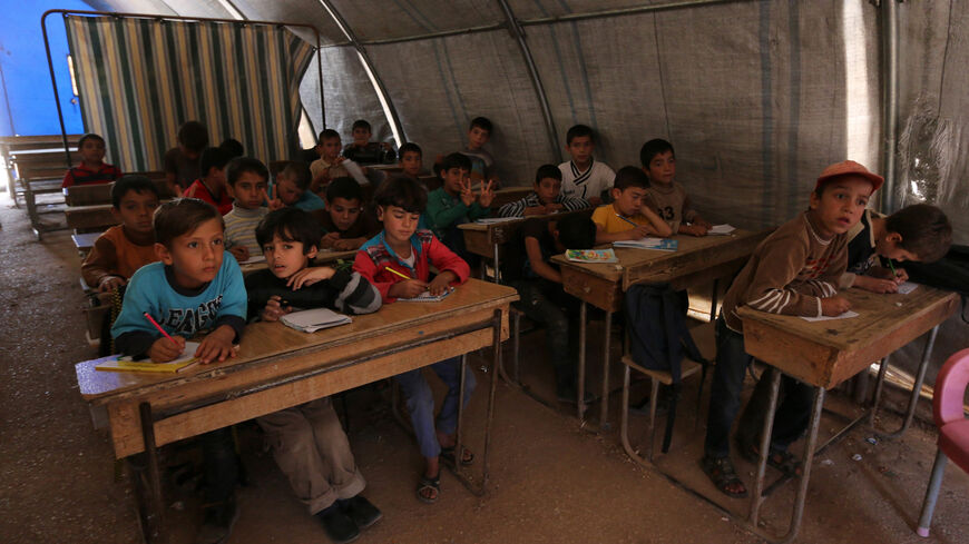 Displaced Syrian children attend a class in Bab al-Salama camp for people fleeing the violence in Syria, on the border with Turkey, Oct. 27, 2014.