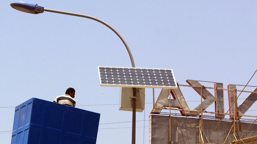 A municipal worker is lowered after adjusting a solar panel.