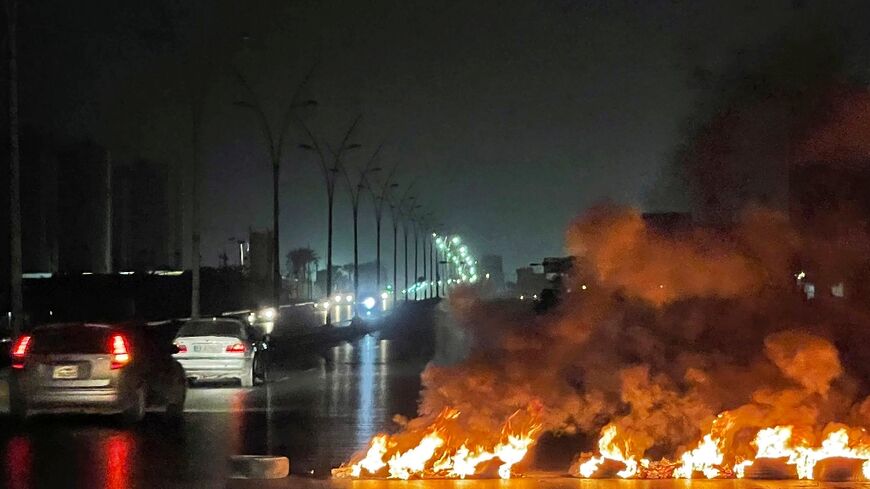 Tyres burnt at a road blockade during overnight protests in the Libyan capital Tripoli