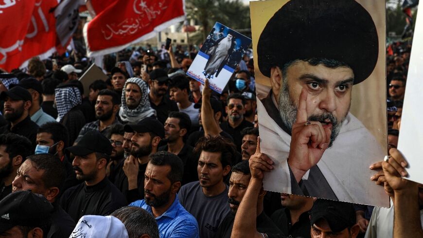 Supporters of Shiite cleric Moqtada Sadr carry portraits of him as they gather in the city of Nasiriyah in Iraq's southern Dhi Qar province on August 12, 2022