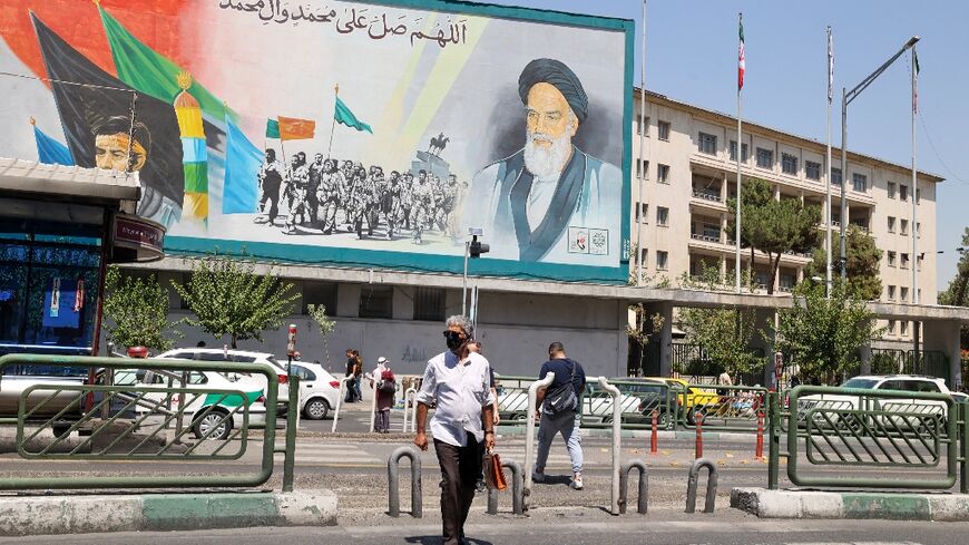 Iranians in Tehran walk past a billboard bearing a portrait of the late supreme leader Ayatollah Ruhollah Khomeini, who in 1989 issued a fatwa calling for author Salman Rushdie to be killed