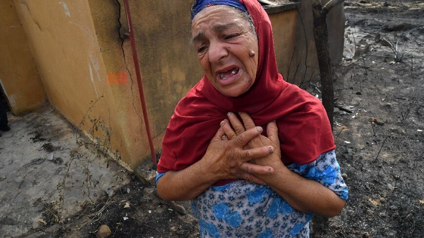 An Algerian woman in front of the ruins of her home, destroyed in a wildfire in the city of el-Kala, on August 18, 2022