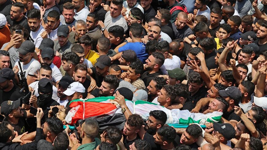 Mourners carry the body of Palestinian commander of the Al-Aqsa Martyrs' Brigade Ibrahim al-Nabulsi, who was killed in an Israeli raid, during a funeral procession in the West Bank city of Nablus