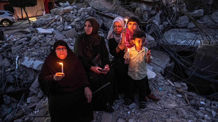 Palestinians hold candles during a rally amid the ruins of houses allegedly destroyed by Israeli airstrikes, Beit Lahia, Gaza City, Gaza Strip, May 25, 2021.