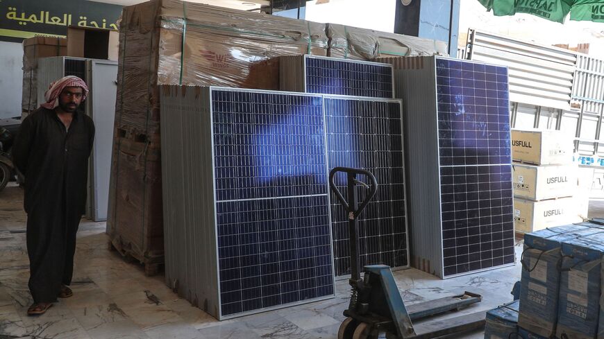 A man stands near solar panels displayed at a shop in the town of Dana, Syria.