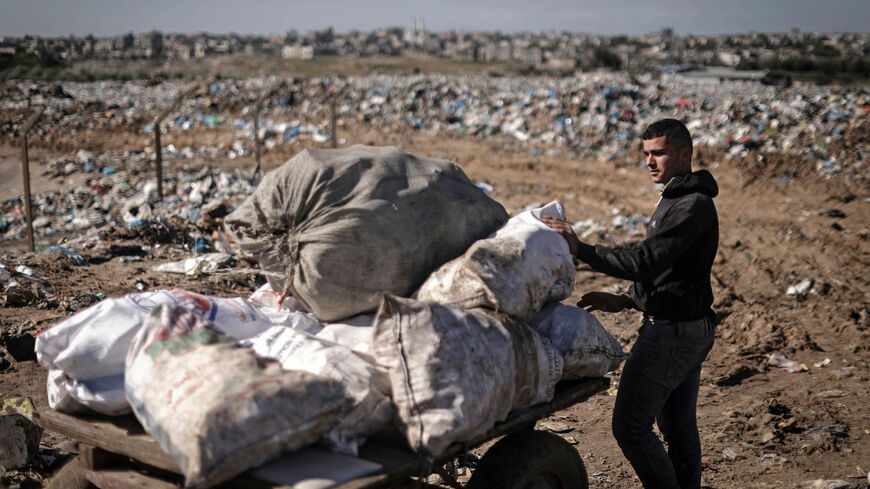 A Palestinian youth collects plastic and iron from a landfill in Beit Lahia, northern Gaza Strip, Jan. 17, 2022.