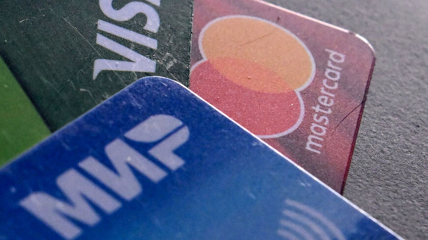 A photo taken on March 14, 2022, shows the logos of Visa, Mastercard and Russian Mir payment systems on bank cards in Moscow.