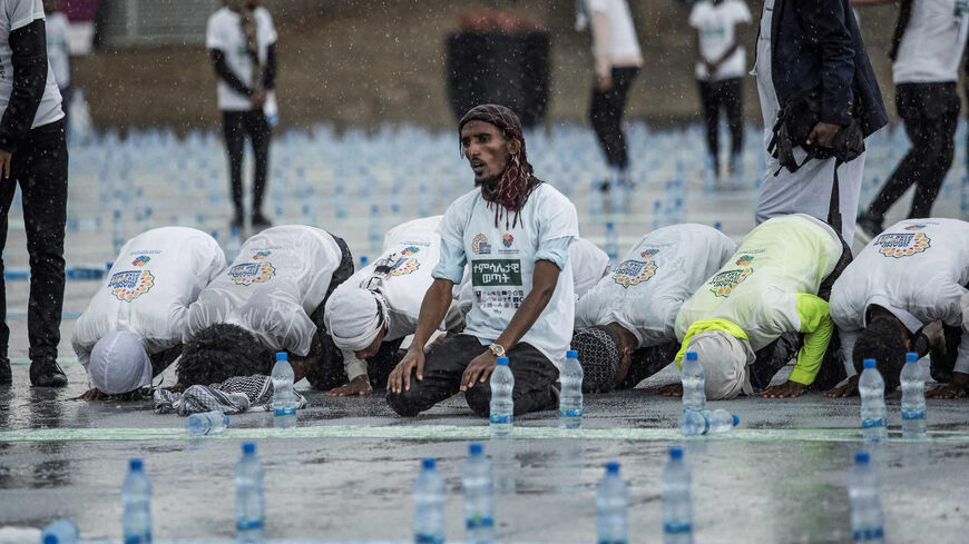 Muslim devotees pray under the rain as they gather at Meskel Square to break their fast during the holy Muslim month of Ramadan, Addis Ababa, Ethiopia, April 29, 2022.