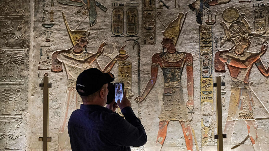 A visitor takes pictures of the hieroglyph-adorned walls in KV11, the Tomb of Pharaoh Ramses III, at the Valley of the Kings on the West Bank of the Nile River, Luxor, Egypt, Jan. 18, 2022.
