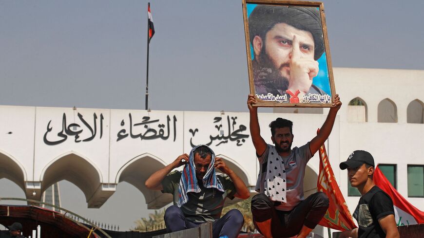 A supporter of Iraqi Muslim Shiite cleric Muqtada al-Sadr raises his portrait.