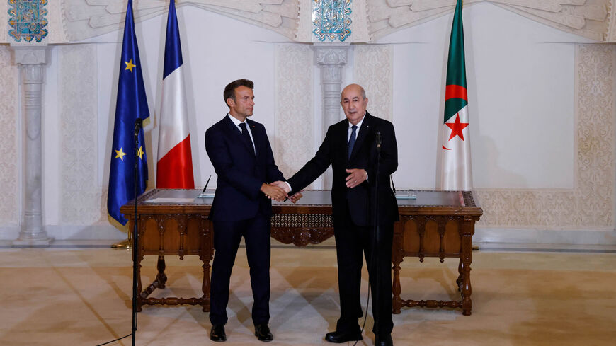 French President Emmanuel Macron (L) and Algeria's President Abdelmadjid Tebboune attend a signing ceremony in the pavilion of honor at Algiers airport, Algiers, Algeria, Aug. 27, 2022.