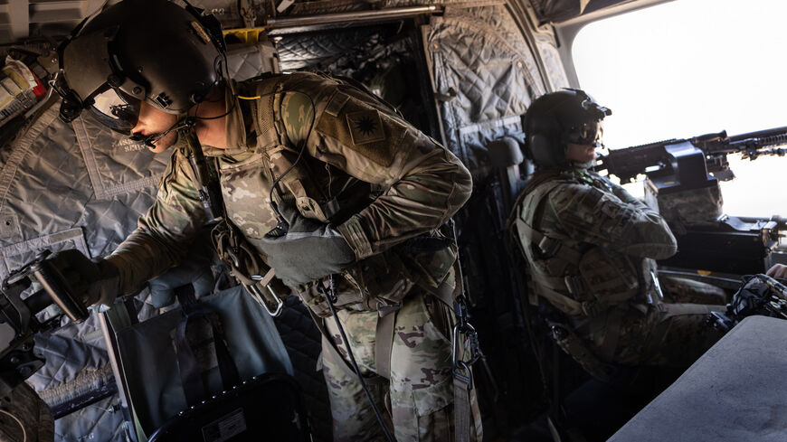 U.S. Army CH-47 Chinook helicopter gunners scan the desert while transporting troops on May 26, 2021, over northeastern Syria. 