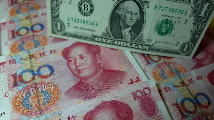 Yuan banknotes and US dollars are seen on a table in Yichang, Hubei province, China, Aug. 14, 2015.