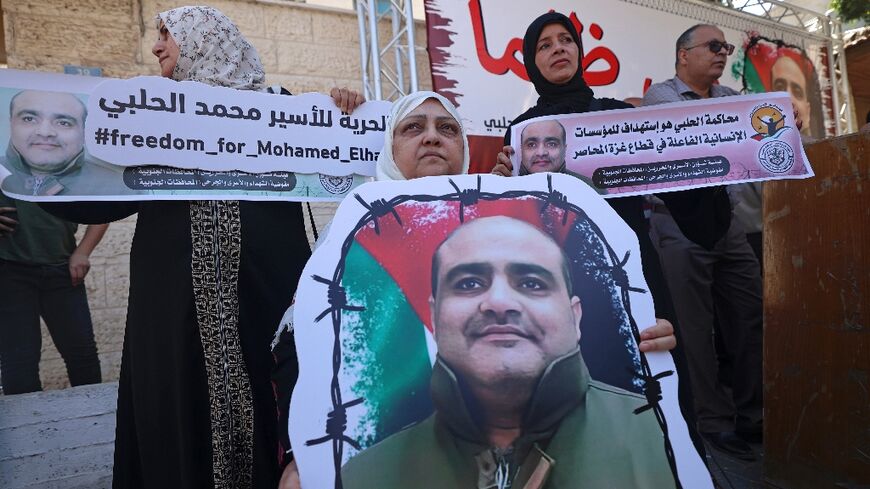 Mohammed Halabi, former Gaza director of World Vision, was sentenced to 12 years in jail on Tuesday for sending cash to Hamas: in this June 2022 photograph his mother holds his portrait in a rally demanding his release