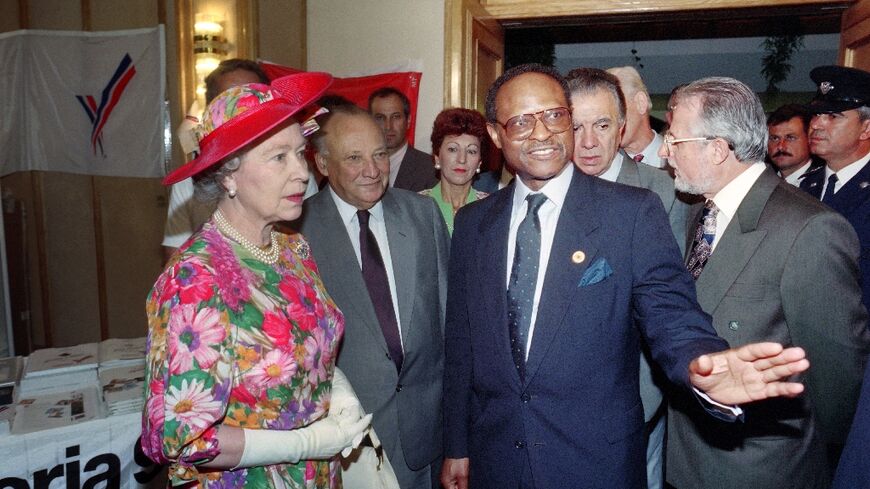 Queen Elizabeth II listens to Commonwealth chief Emeka Anyaoku of Nigeria (R) as Cypriot President Glafcos Clerides (C) looks on during the Queen's visit to the press centre in Limassol on October 20, 1993
