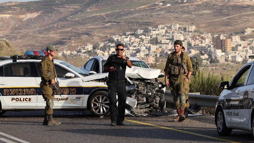 Israeli troops are pictured at the scene in the occupied West Bank where a Palestinian driver was shot dead after what the army called an "attempted ramming attack" but Palestinians said was a traffic accident