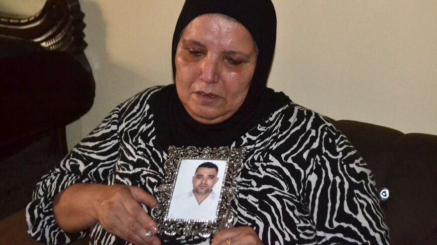 A woman in the northern Lebanese city of Tripoli holds a photograph of her son who drowned a day earlier in a boat carrying migrants that sank off the Syrian coast