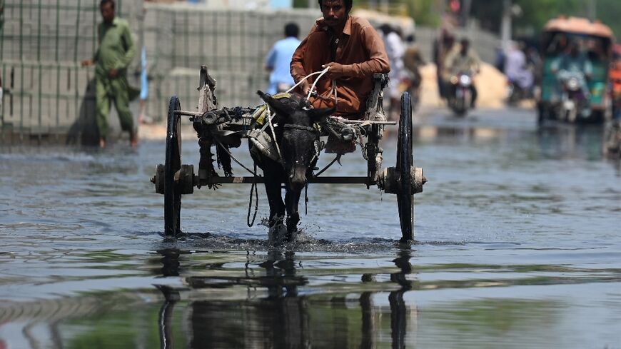A man rides on donkey-cart through a flooded street after heavy monsoon rains in Jacobabad, Pakistan
