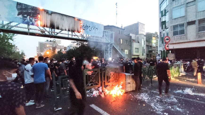 A picture obtained by AFP outside Iran shows protesters burning a rubbish bin in the capital Tehran