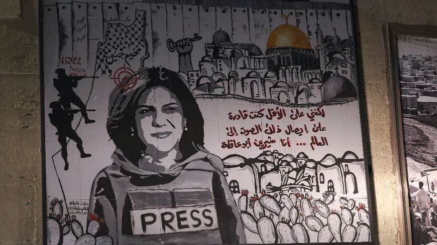 A mural depicting slain Palestinian-American journalist Shireen Abu Akleh is illuminated with headlights on a street in the Arab town of Umm Al-Fahm in northern Israel, on September 5, 2022