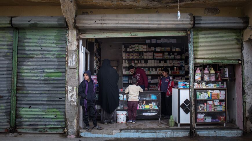 People shop at a pharmacy on February 16, 2019, in Hajin, Syria. 