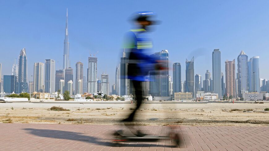 A man rides his electric scooter in Dubai backdropped by the Gulf emirate's high-rise buildings on February 16, 2021.
