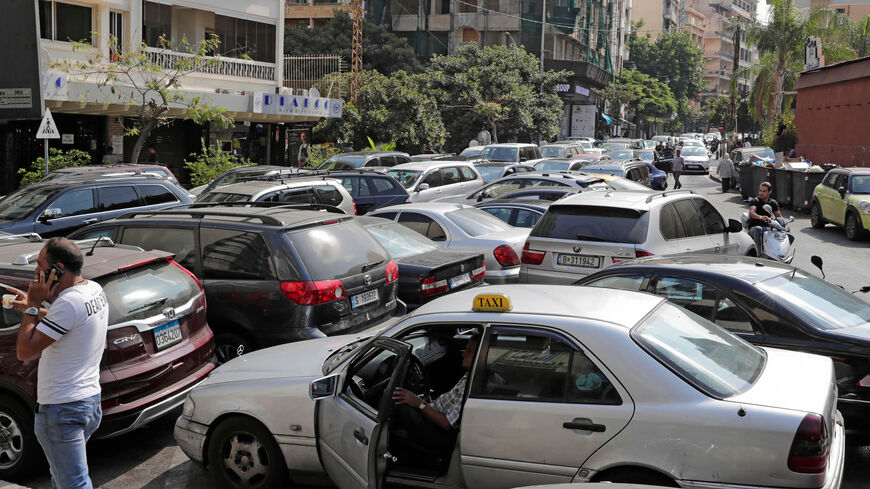 Lebanese wait in a line outside a closed petrol station, Hamra district, Beirut, Lebanon, Aug. 20, 2021.