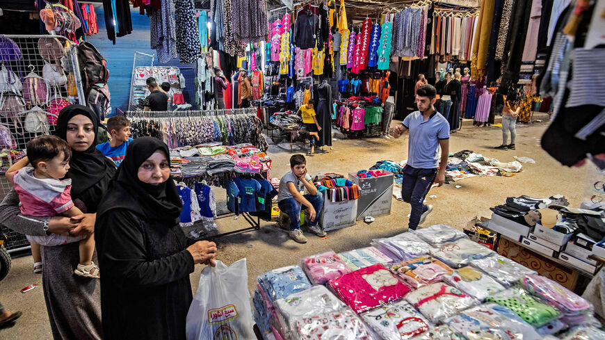 Syrians shop in a market in the northern city of Manbij, located near the border with Turkey, Syria, July 21, 2022.