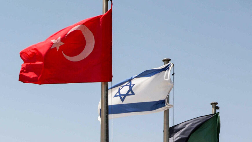 The flags of (L to R) Turkey, Israel, and the Israeli army armoured corps fly at the Yad La-Shiryon Tank Museum in Latrun, about 30 kilometres west of Jerusalem, on August 18, 2022. - Israel and Turkey on August 16 announced the resumption of full diplomatic ties following years of strained relations between the Mediterranean nations. Israeli Prime Minister Yair Lapid hailed the step as an "important asset for regional stability and very important economic news for the citizens" of the Jewish state. Lapid h