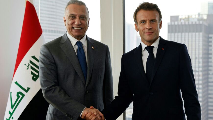 French President Emmanuel Macron (R) and Iraqi Prime Minister Mustafa al-Kadhimi shake hands during a meeting in New York.