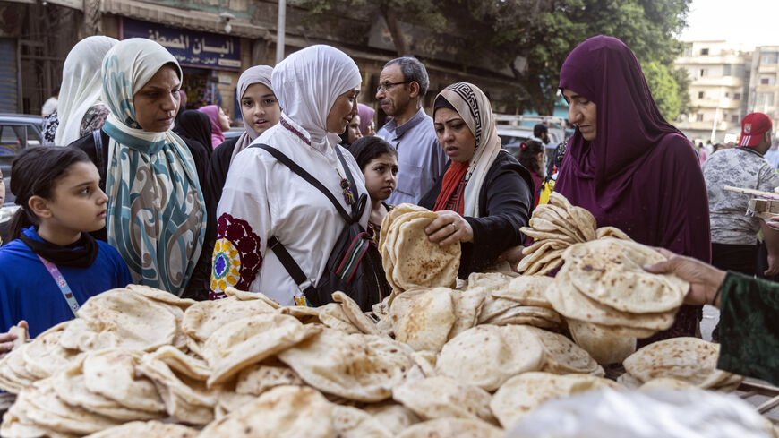 Women buy bread from a local bread stand in al-Fustat neighborhood, Cairo, Egypt, May 2, 2022.