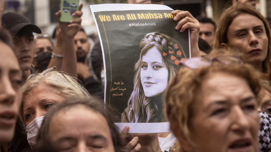 People hold signs and chant slogans during a protest over the death of Iranian Mahsa Amini.