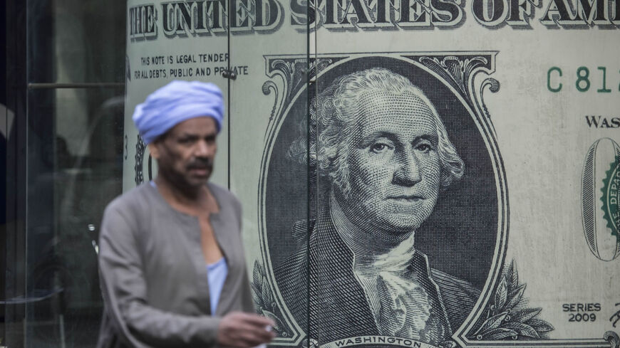 A man walks past a currency exchange shop displaying a giant US dollar banknote, Cairo, Egypt, Nov. 3, 2016.