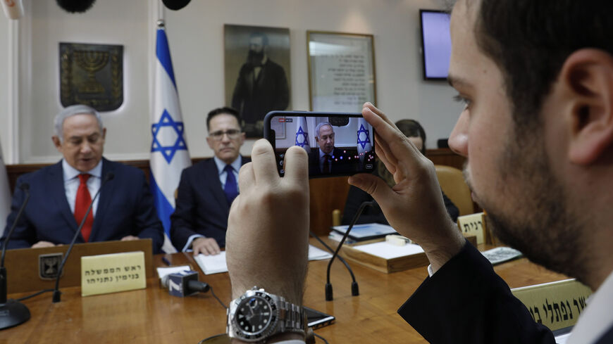 A media adviser of Israeli Prime Minister Benjamin Netanyahu makes a Facebook live broadcast as he opens the weekly Cabinet meeting at his office, Jerusalem, Jan. 21, 2018.