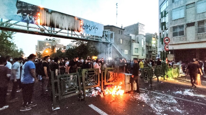 A picture obtained by AFP outside Iran on September 21 shows Iranian demonstrators burning a rubbish bin in the capital Tehran during a protest for Mahsa Amini following her death