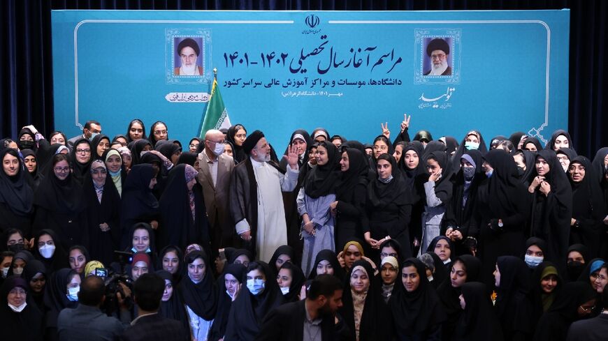 Iran's ultraconservative President Ebrahim Raisi poses for a group photograph with female students at Tehran's Al-Zahra university at the start of the new academic year