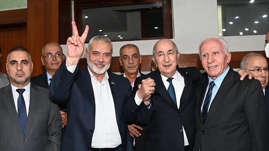 Algerian President Abdelmadjid Tebboune (C) poses with Hamas leader Ismail Haniyeh and Fatah member Azzam al-Ahmad (R) 