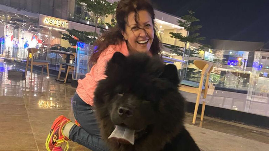 Ola Loutfi is seen with one of her dogs in front of the Dog Cafe, 6 October City, Giza governorate, Egypt, October 2022.